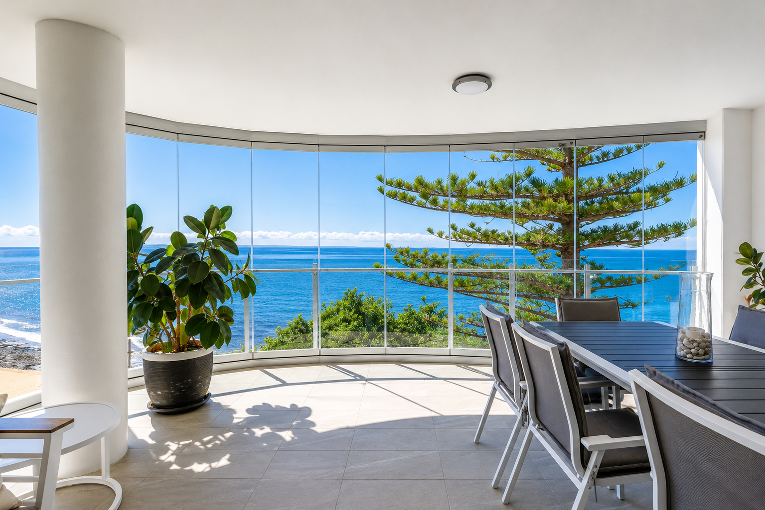Cyclone-rated frameless glass screens on Redcliffe balcony with sea view